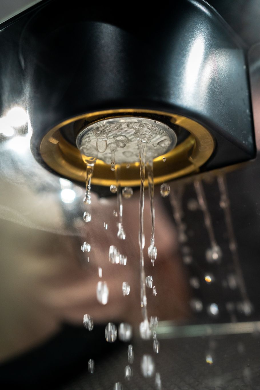 Extracción de café en macro, agua pasando por el filtro de una máquina La Norma